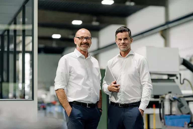 Porträt von zwei selbstbewussten Geschäftspartnern in einer Fabrik